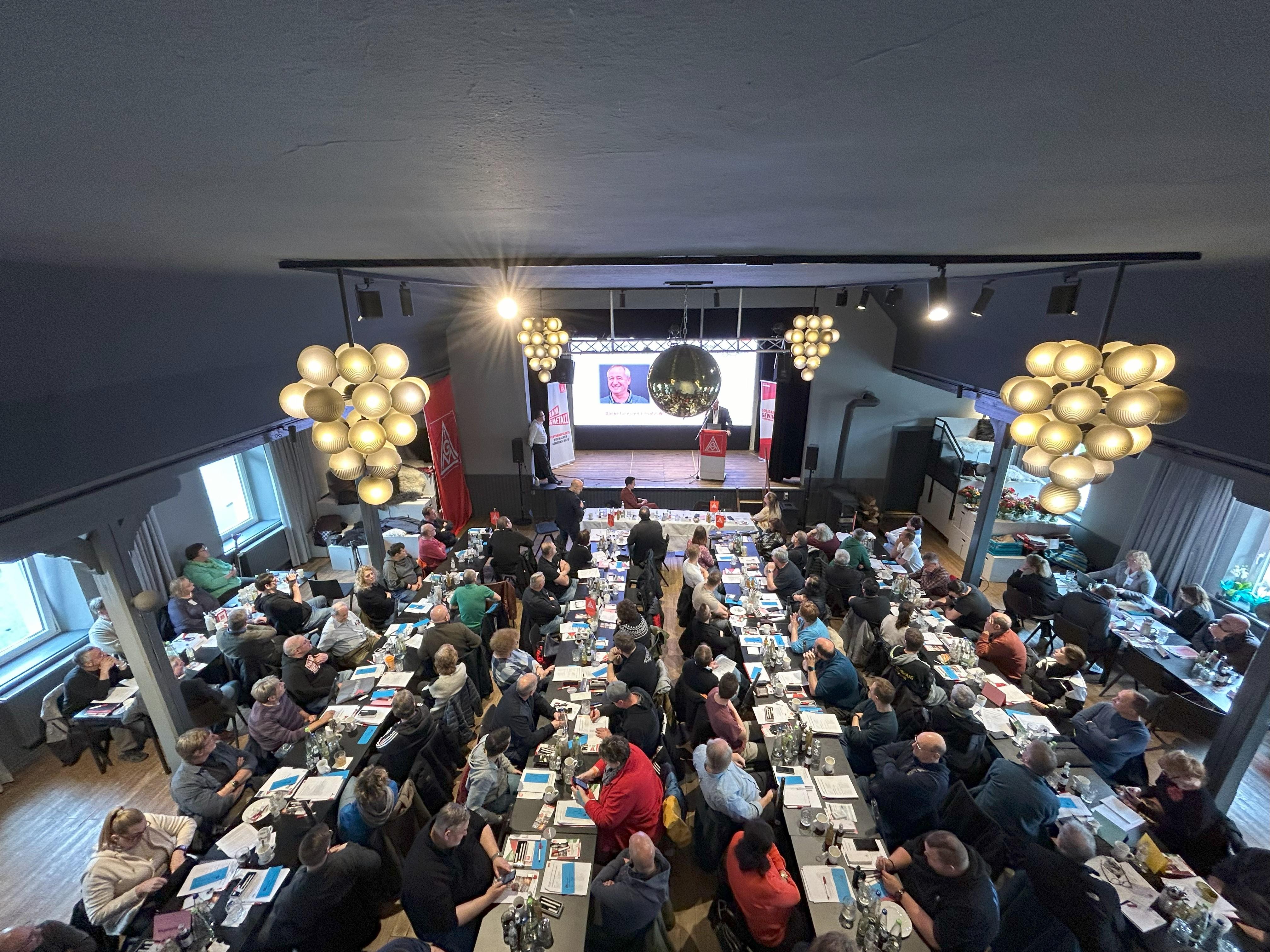 Das Plenum der Delegiertenversammlung Westmittelfranken sitzt in einem festlichen Saal und hört den Reden zu.