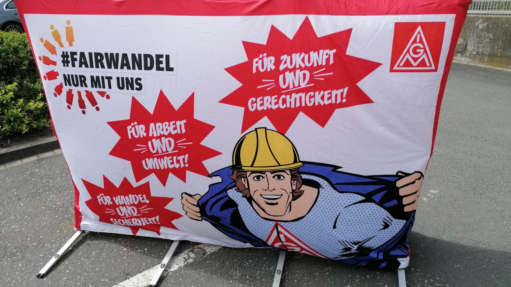 Große Fairwandel-Werbewand mit einem Arbeiter im Comicstil.