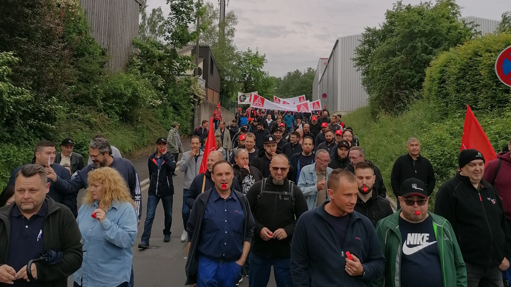 Die Beschäftigten von ElringKlinger demonstrieren durch Langenzenn und halten dabei IG Metall-Fahnen und Banner hoch.