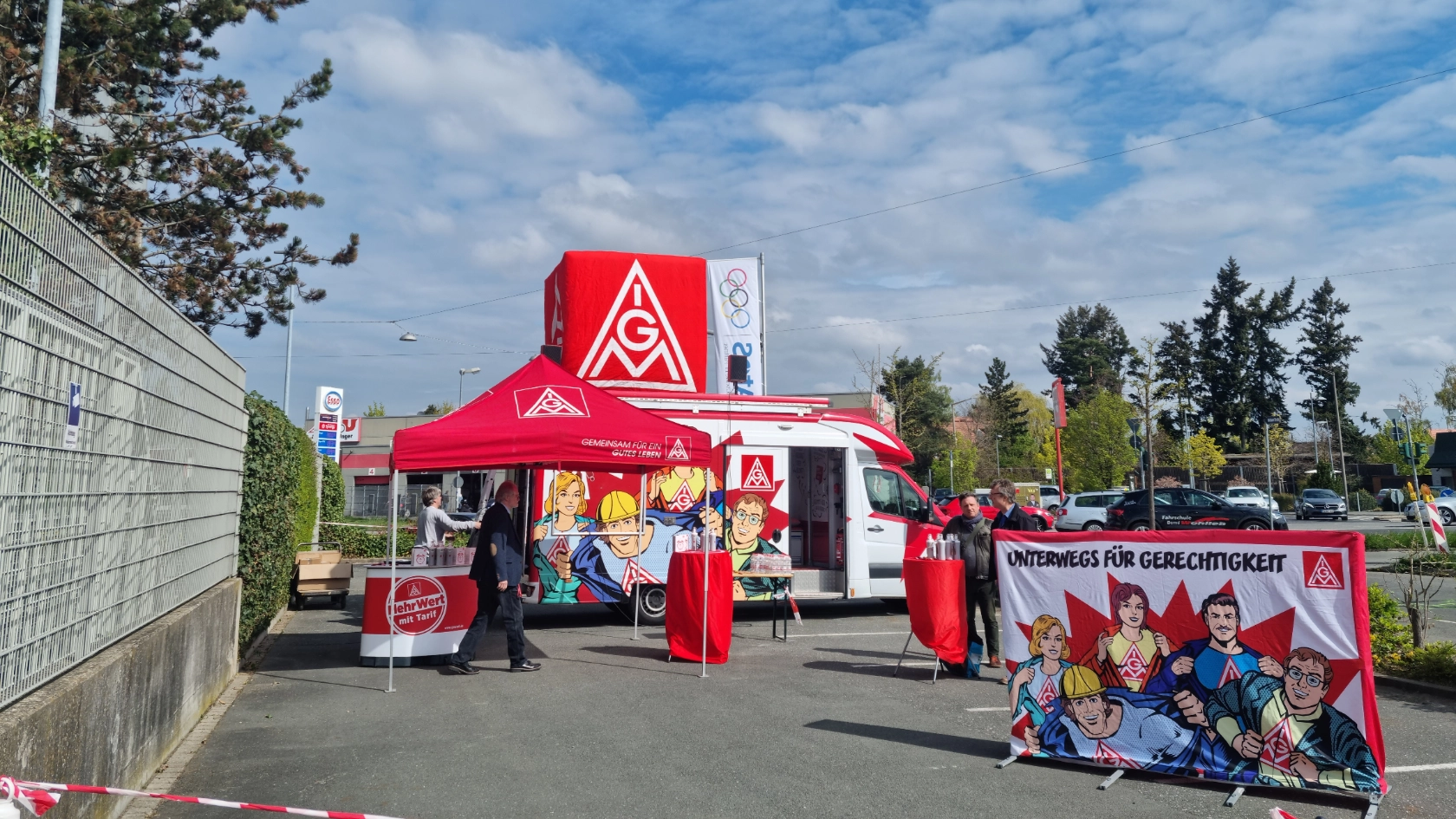 Roter Truck der Roadshow mit rotem IG Metall-Pavillon, Stehtischen, Werbewand Fairwandel und Werbematerialien