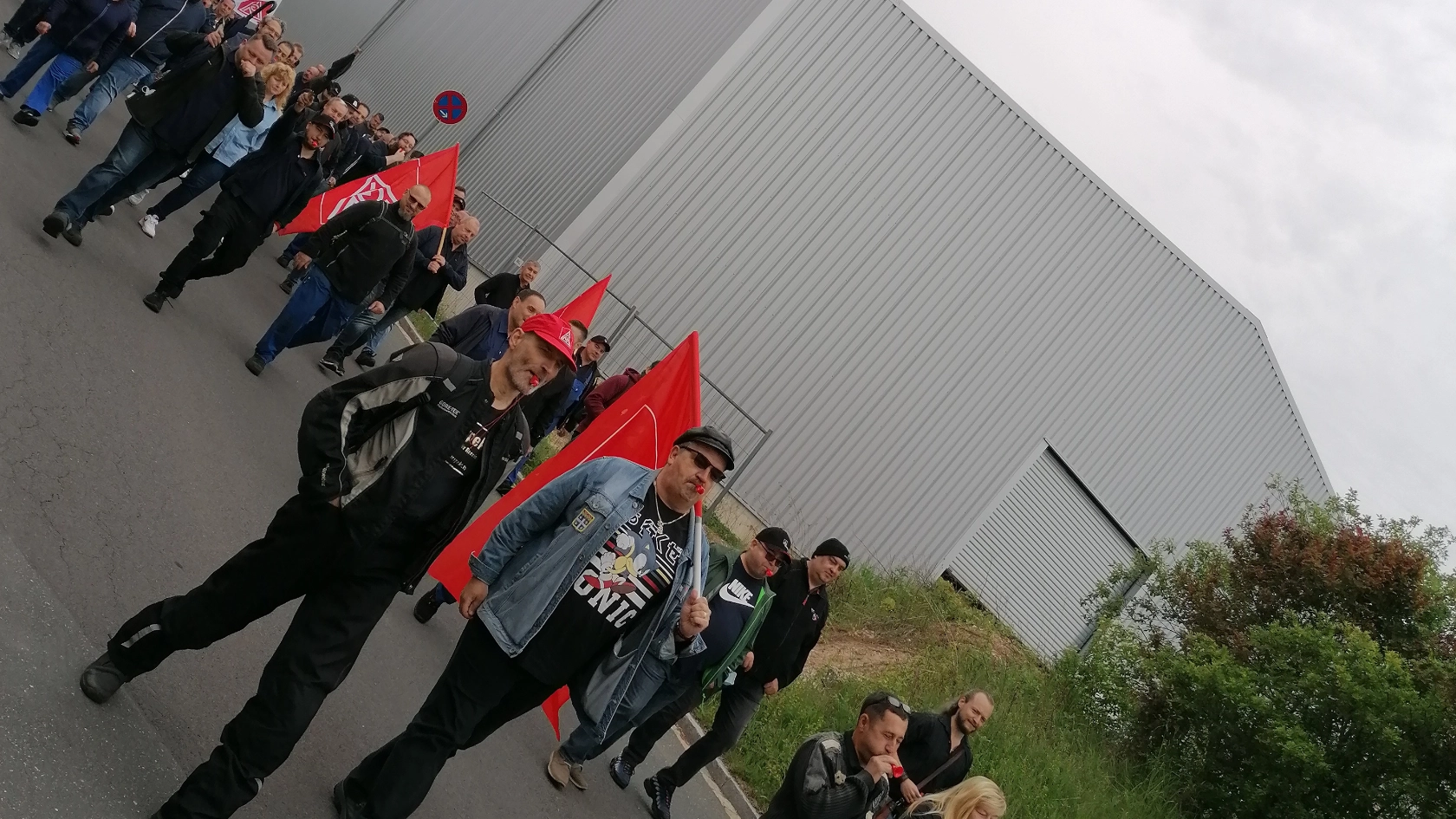 Die Beschäftigten von Elring Klinger in Langenzenn demonstrieren vor dem Werk mit IG Metall-Fahnen und Bannern.