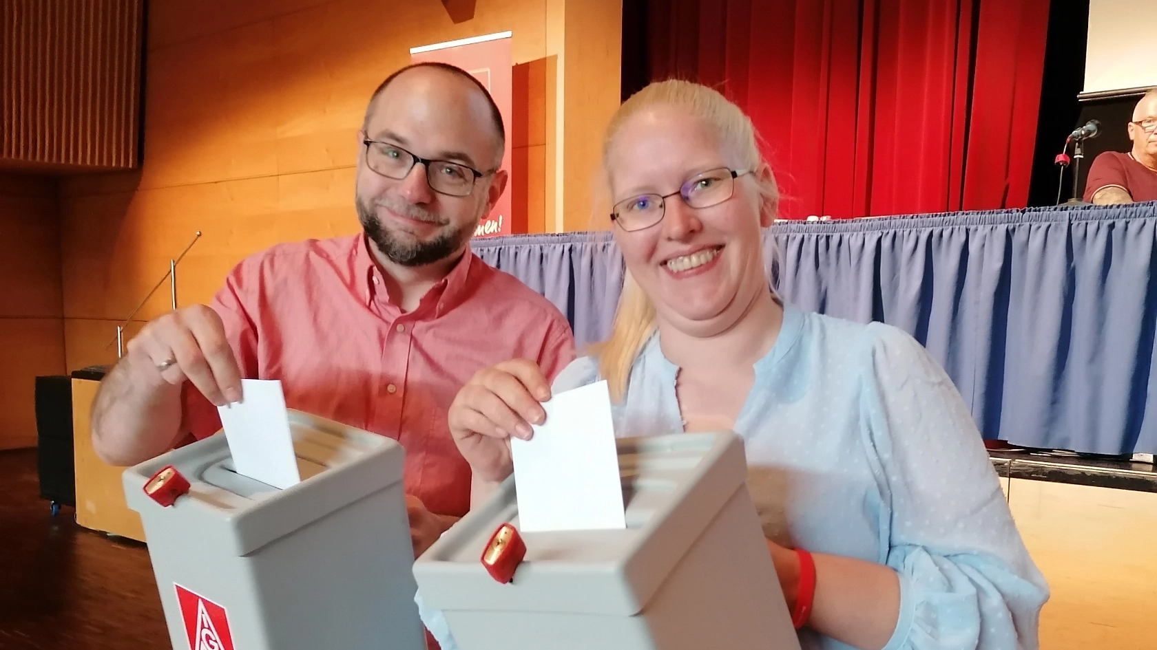 Zwei Wahlhelfer:innen tragen die Wahlurnen zur Nachwahl des 2. Bevollmächtigten 
