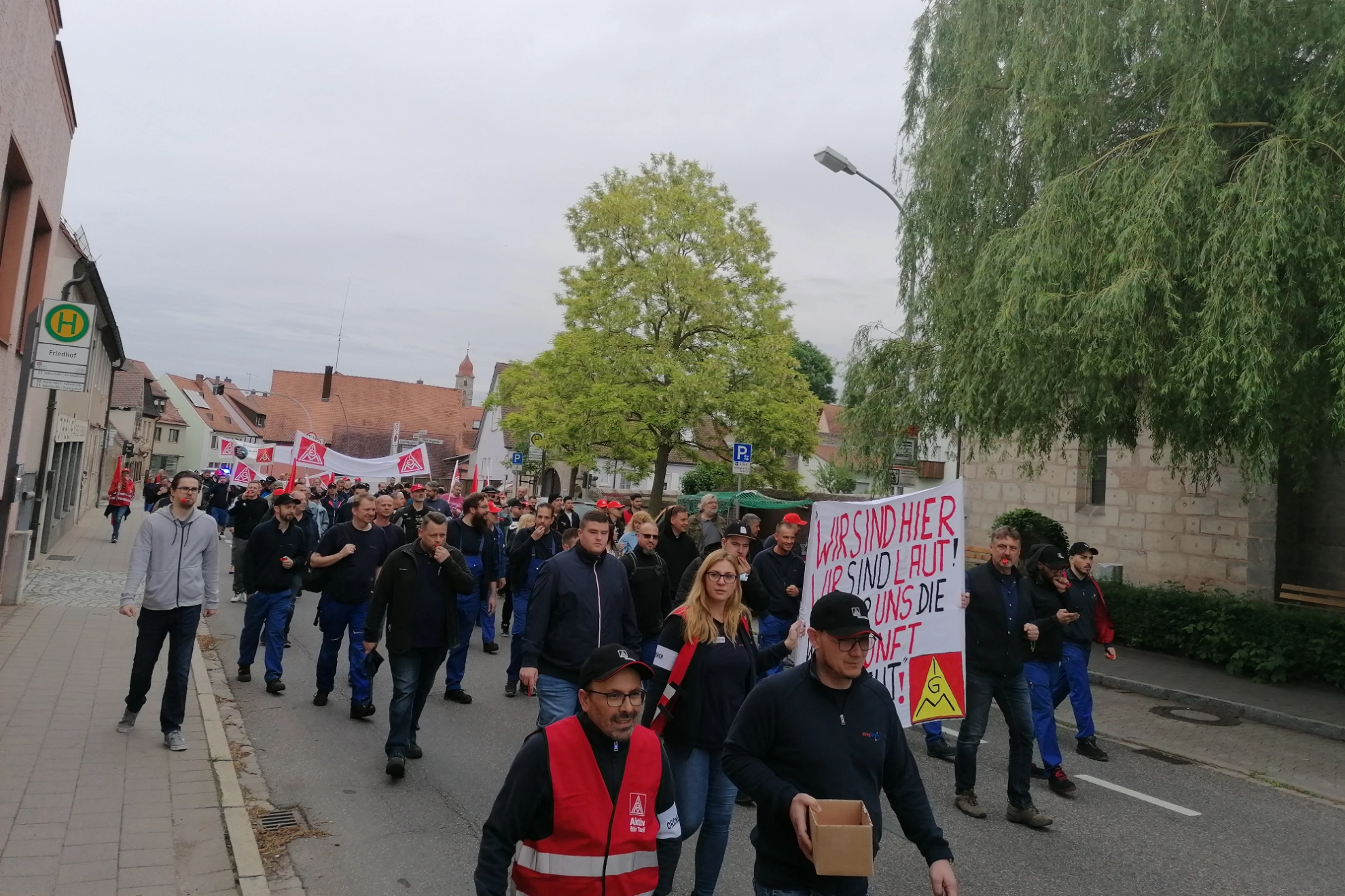 Die Beschäftigten von ElringKlinger demonstrieren mit IG Metall-Fahnen und Banner wegen ihrer geplanten Betriebsschließung durch Langenzenn.