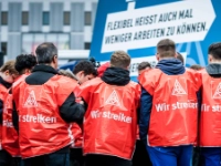 Eine Gruppe junge Männer mit roten Streikwesten.