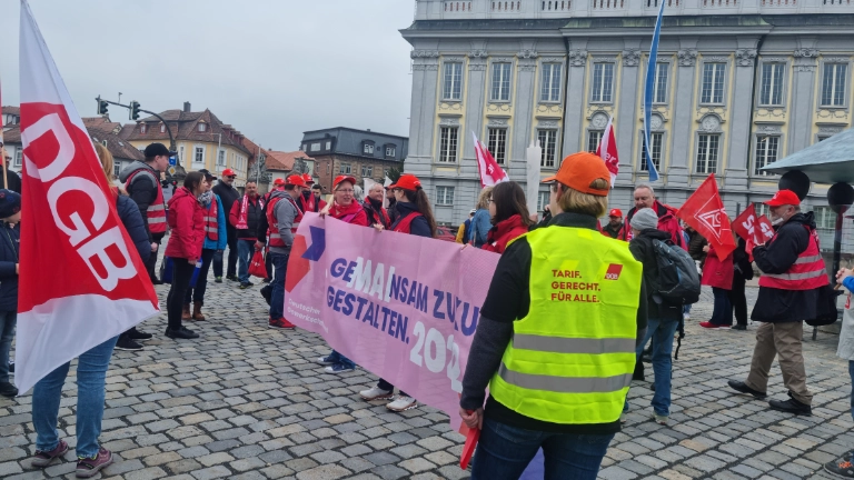 Gewerkschafter*innen sammeln sich zum Demozug zum 1. Mai in Ansbach mit dem Banner des DGB.