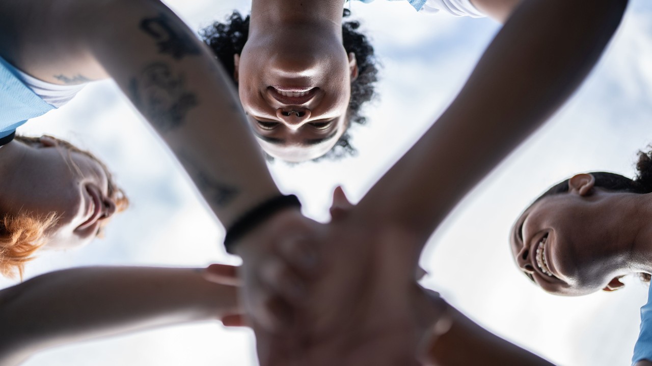 Junge Frauen reichen sich die Hände